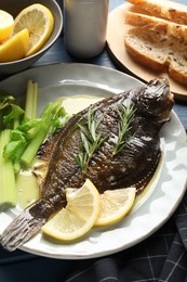 Photo of Tasty roasted flounder fish with celery served on blue table, closeup. Homemade seafood dish