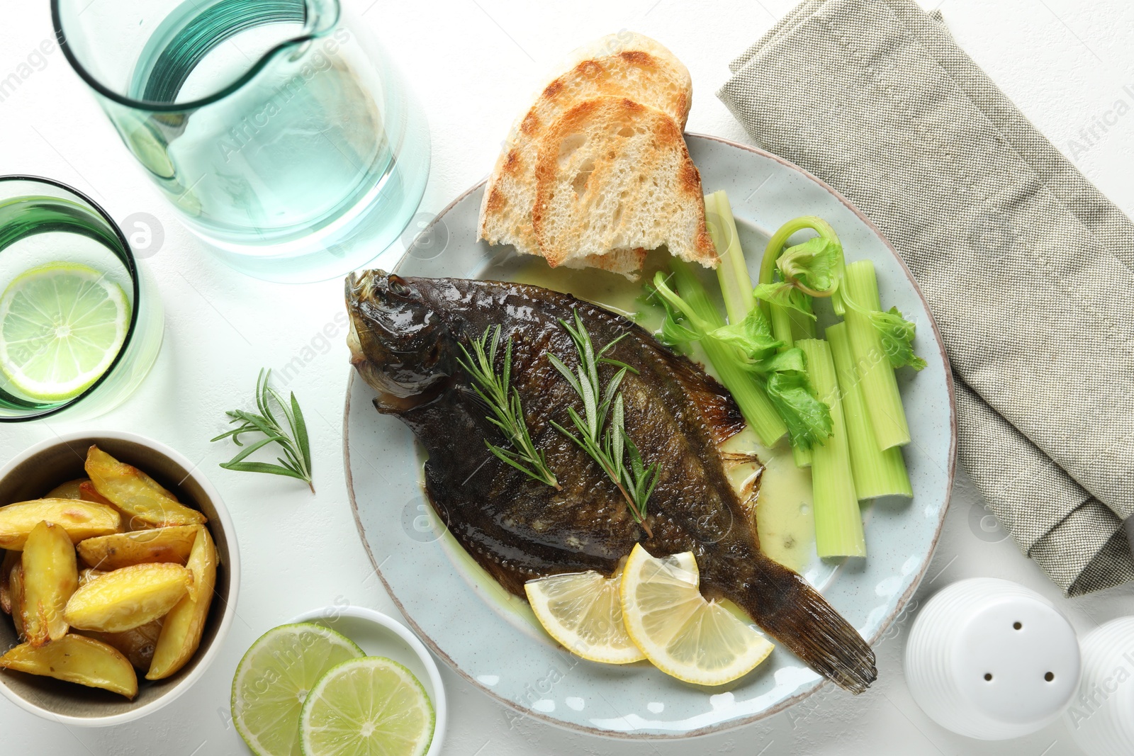 Photo of Tasty roasted flounder fish with celery served on white table, flat lay. Homemade seafood dish