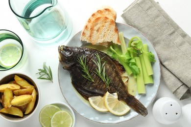 Photo of Tasty roasted flounder fish with celery served on white table, flat lay. Homemade seafood dish