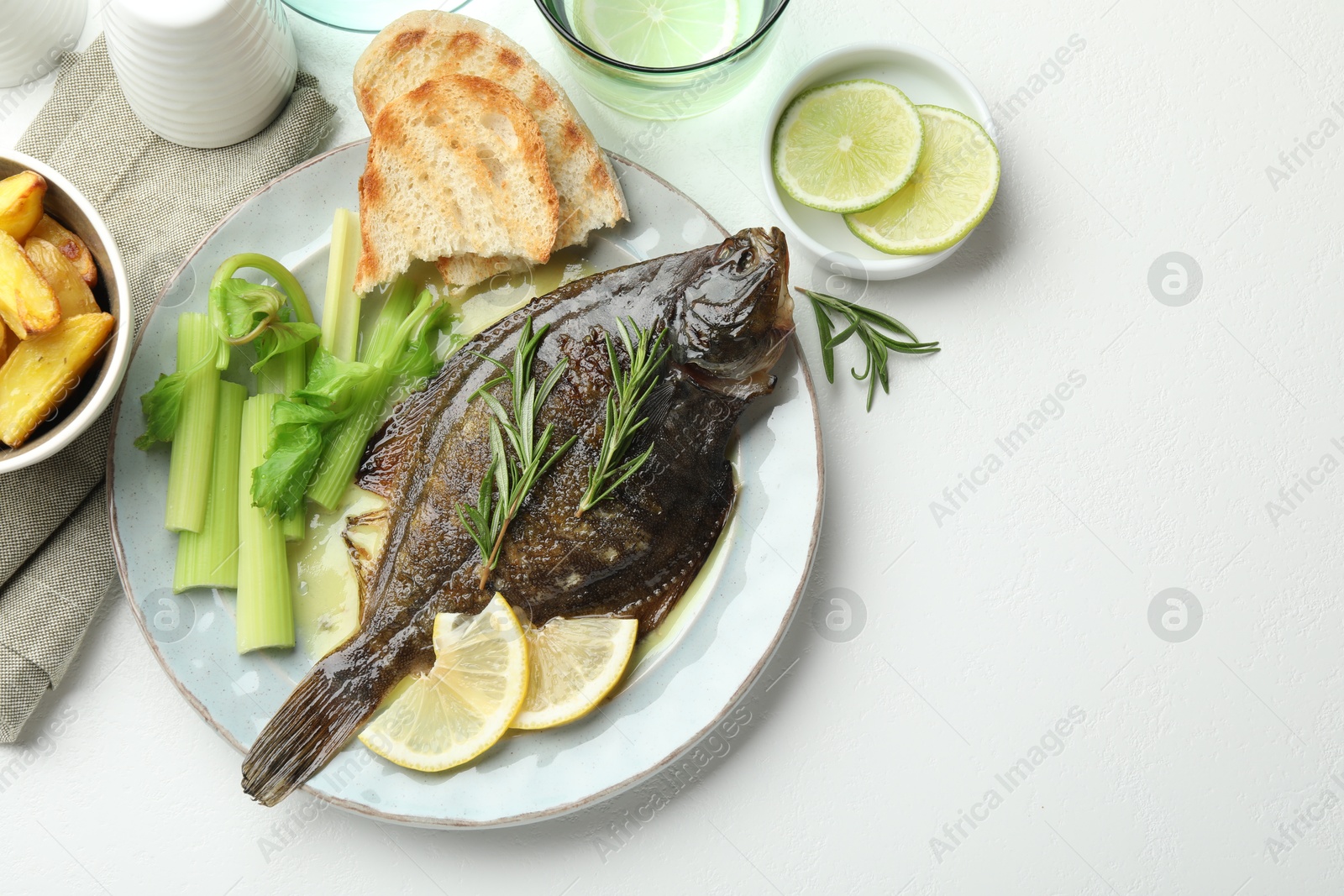 Photo of Homemade seafood dish. Tasty roasted flounder fish with celery served on white table, flat lay. Space for text