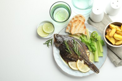Photo of Homemade seafood dish. Tasty roasted flounder fish with celery served on white table, flat lay. Space for text