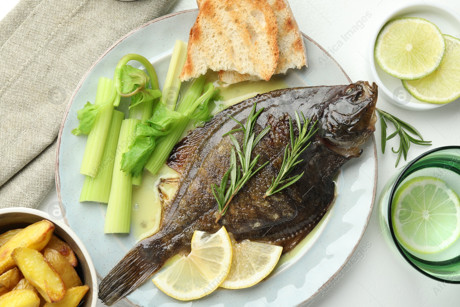 Photo of Tasty roasted flounder fish with celery served on white table, flat lay. Homemade seafood dish