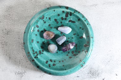Photo of Aura. Different natural mineral stones on white textured table, top view