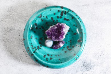 Photo of Aura. Different natural mineral stones on white textured table, top view