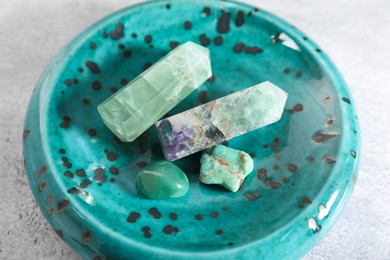 Photo of Aura. Different natural mineral stones on white textured table, closeup