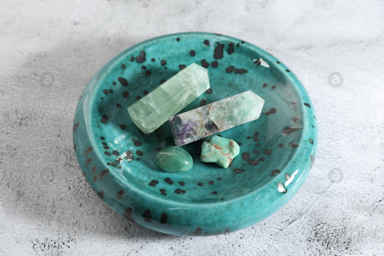 Photo of Aura. Different natural mineral stones on white textured table, closeup