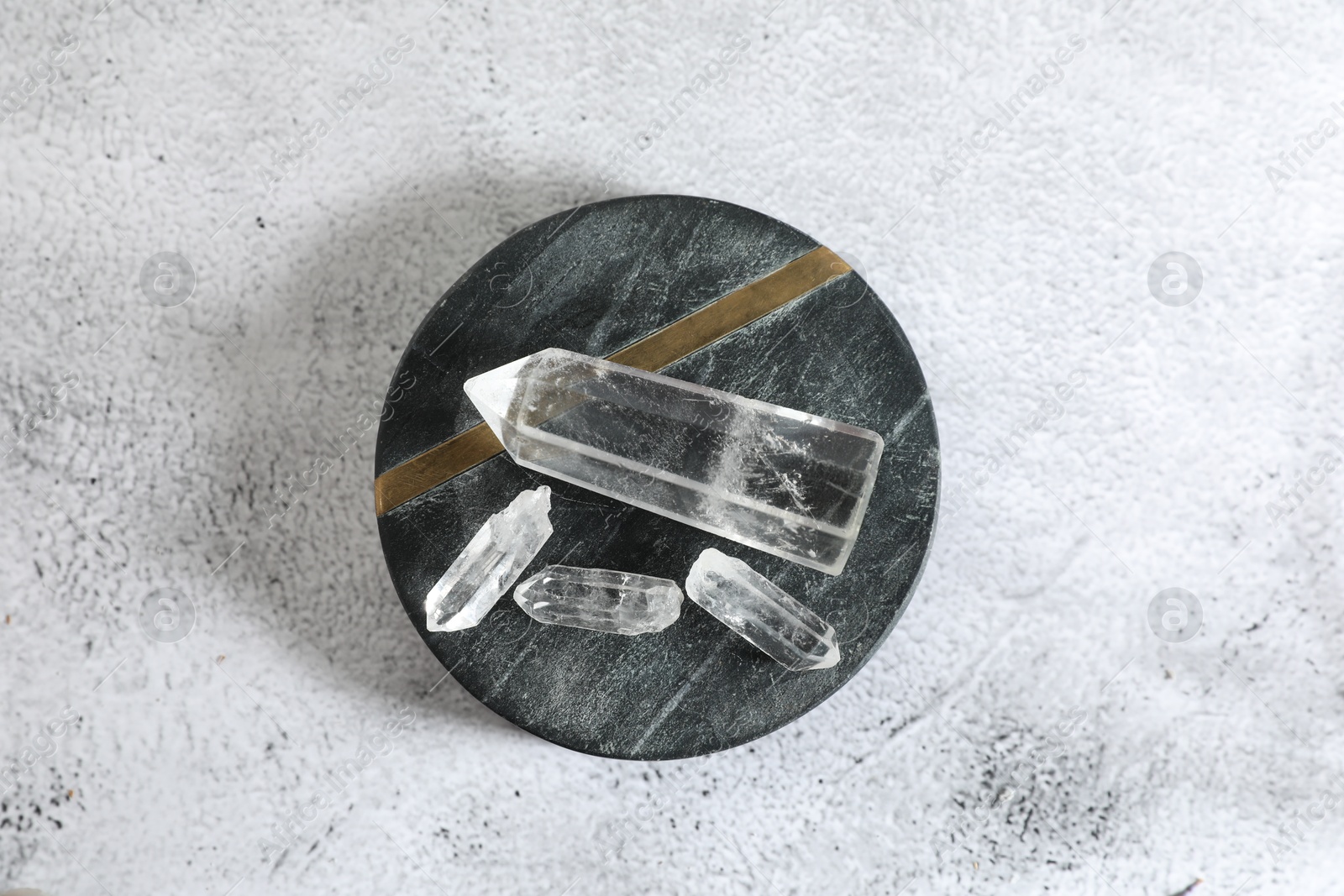 Photo of Aura. Beautiful crystals on white textured table, top view