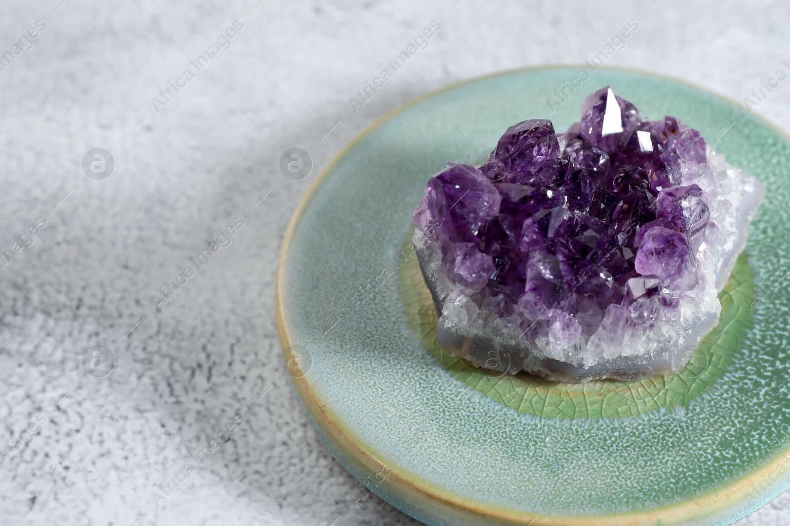 Photo of Aura. Beautiful amethyst on white textured table, closeup. Space for text