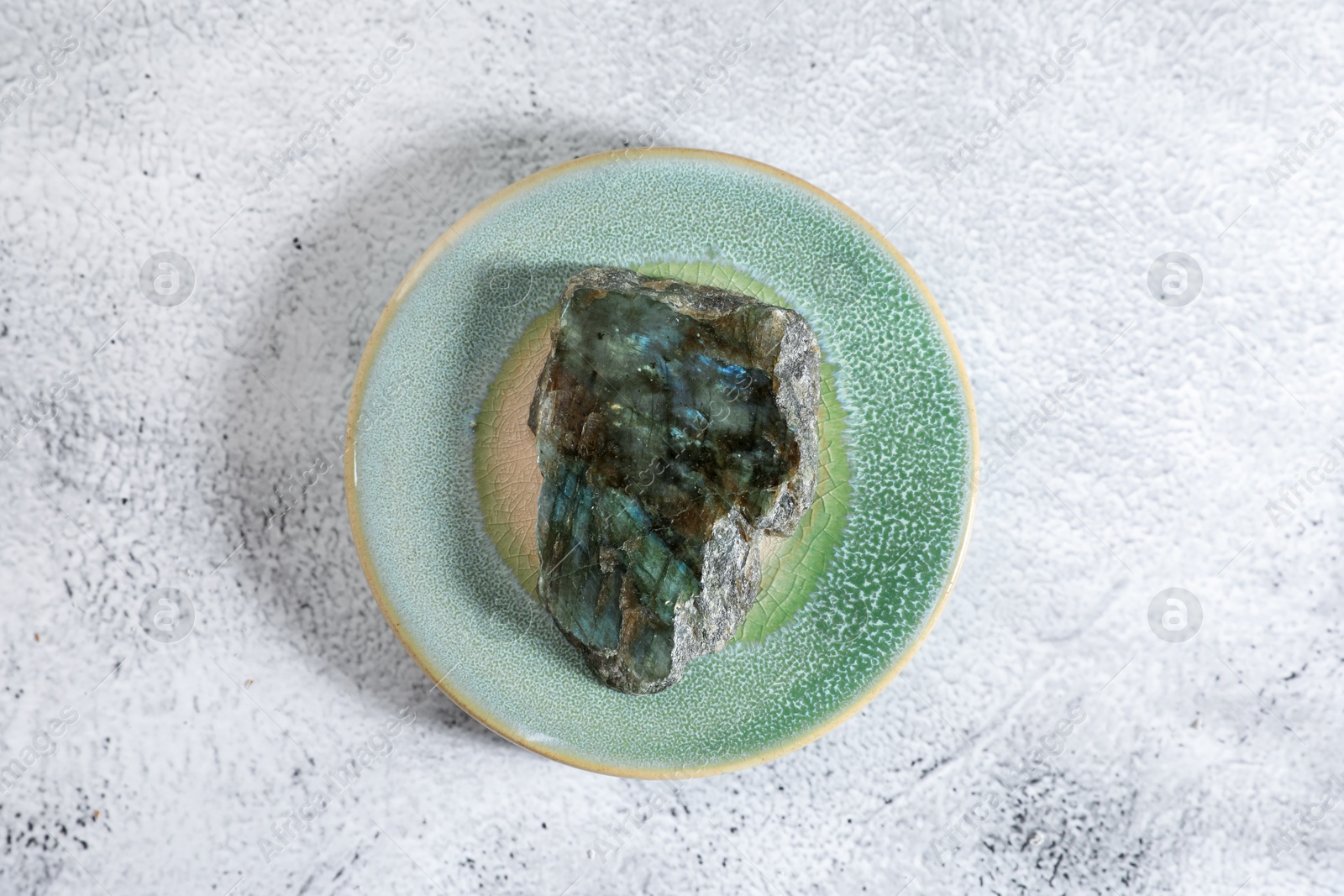 Photo of Aura. Beautiful labradorite on white textured table, top view