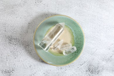 Photo of Aura. Beautiful crystals on white textured table, top view