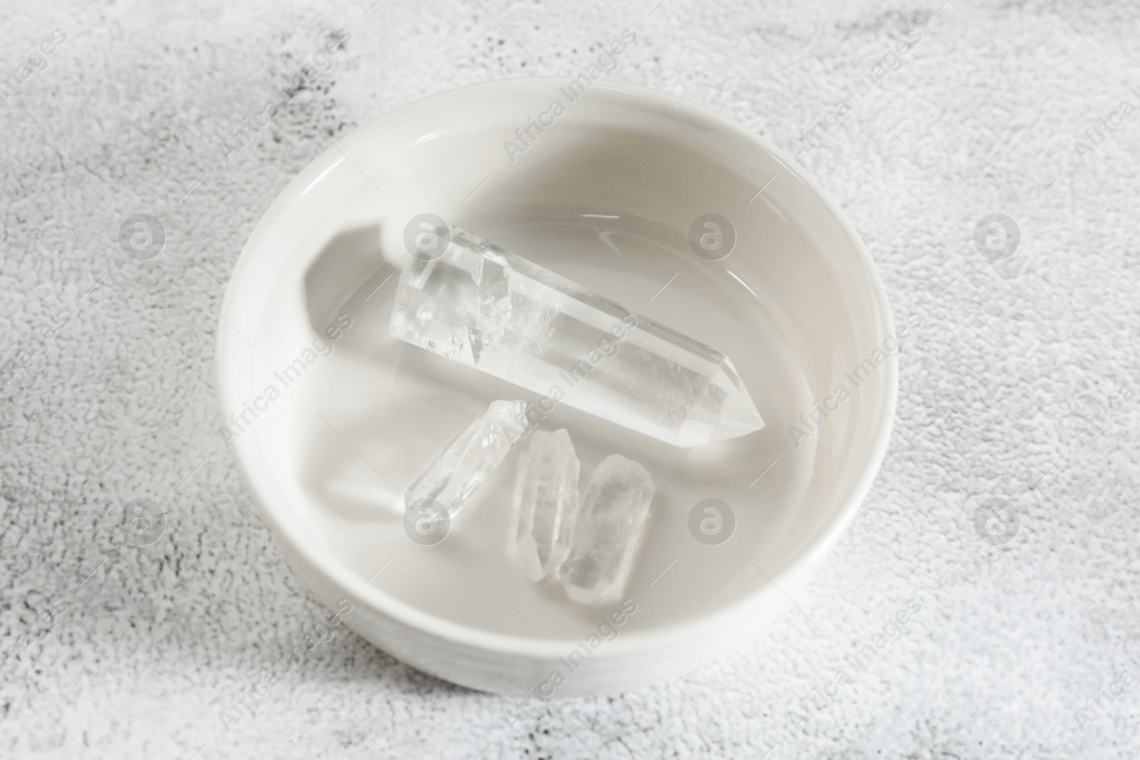 Photo of Aura. Beautiful crystals on white textured table, above view