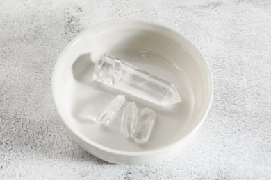 Photo of Aura. Beautiful crystals on white textured table, above view