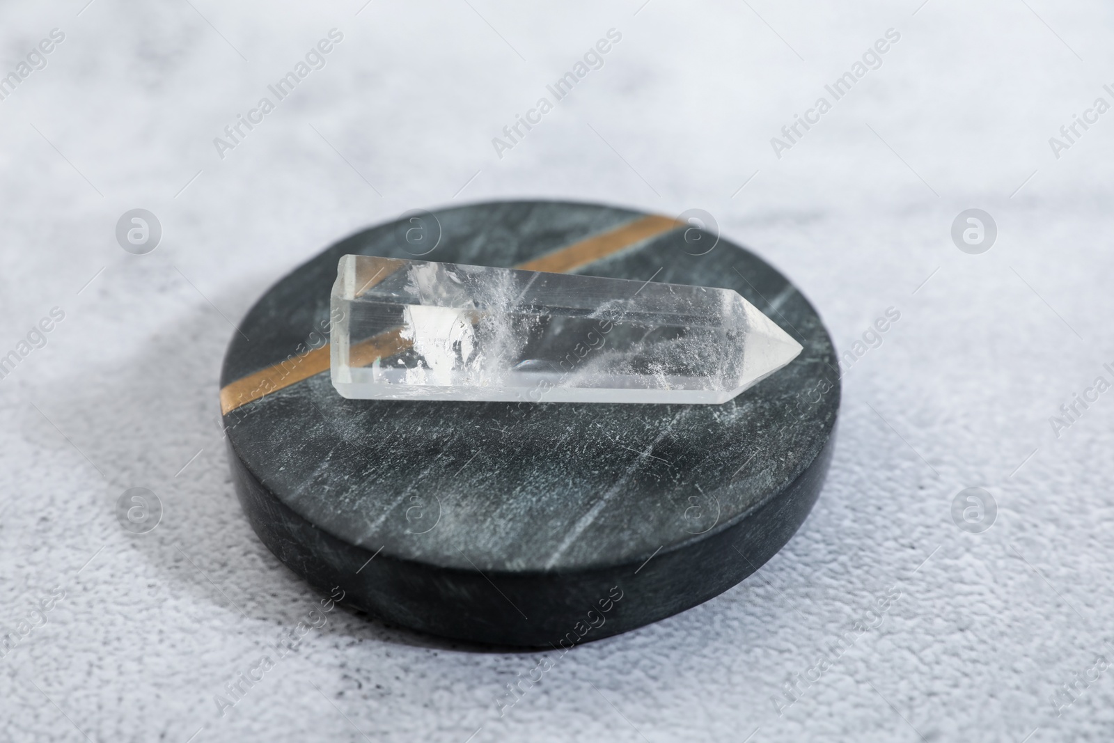 Photo of Aura. Beautiful crystal on white textured table, closeup