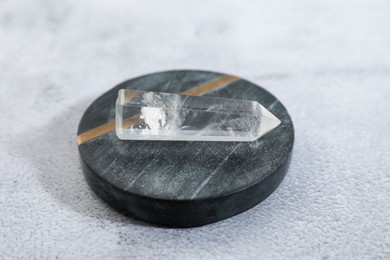 Photo of Aura. Beautiful crystal on white textured table, closeup
