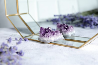 Photo of Aura. Beautiful amethyst and lavender on white textured table, closeup
