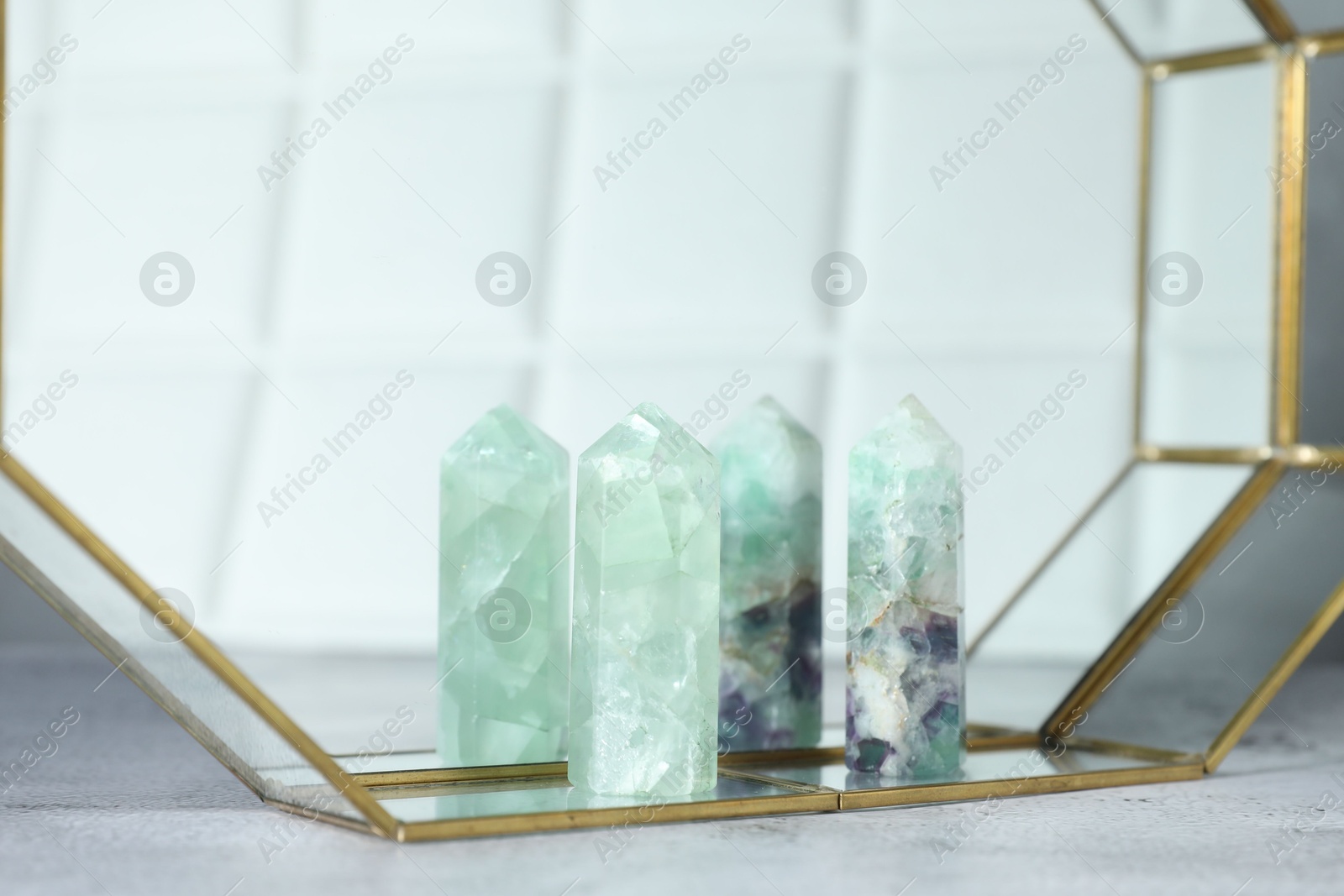 Photo of Aura. Beautiful fluorites on white textured table, closeup