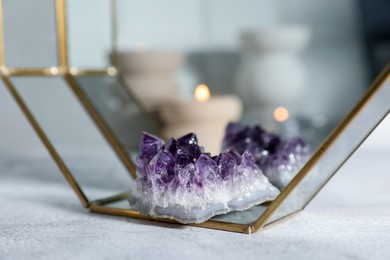 Photo of Aura. Beautiful amethyst on white textured table, closeup