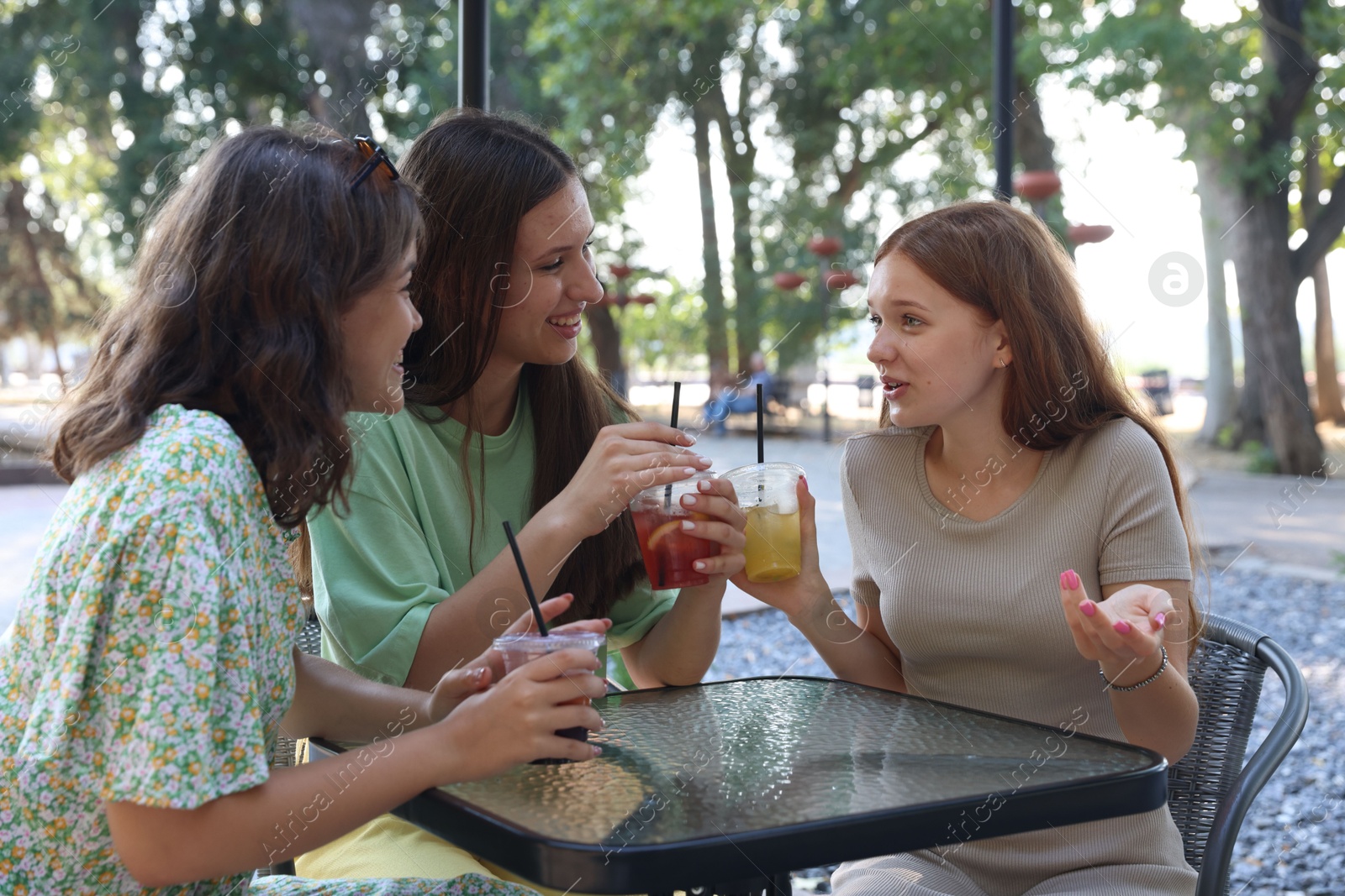 Friends enjoying refreshing drinks in outdoor cafe Photo of Friends enjoying refreshing drinks in outdoor cafe