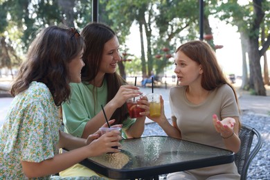 Photo of Friends enjoying refreshing drinks in outdoor cafe