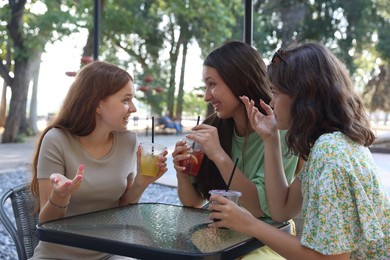 Photo of Friends enjoying refreshing drinks in outdoor cafe