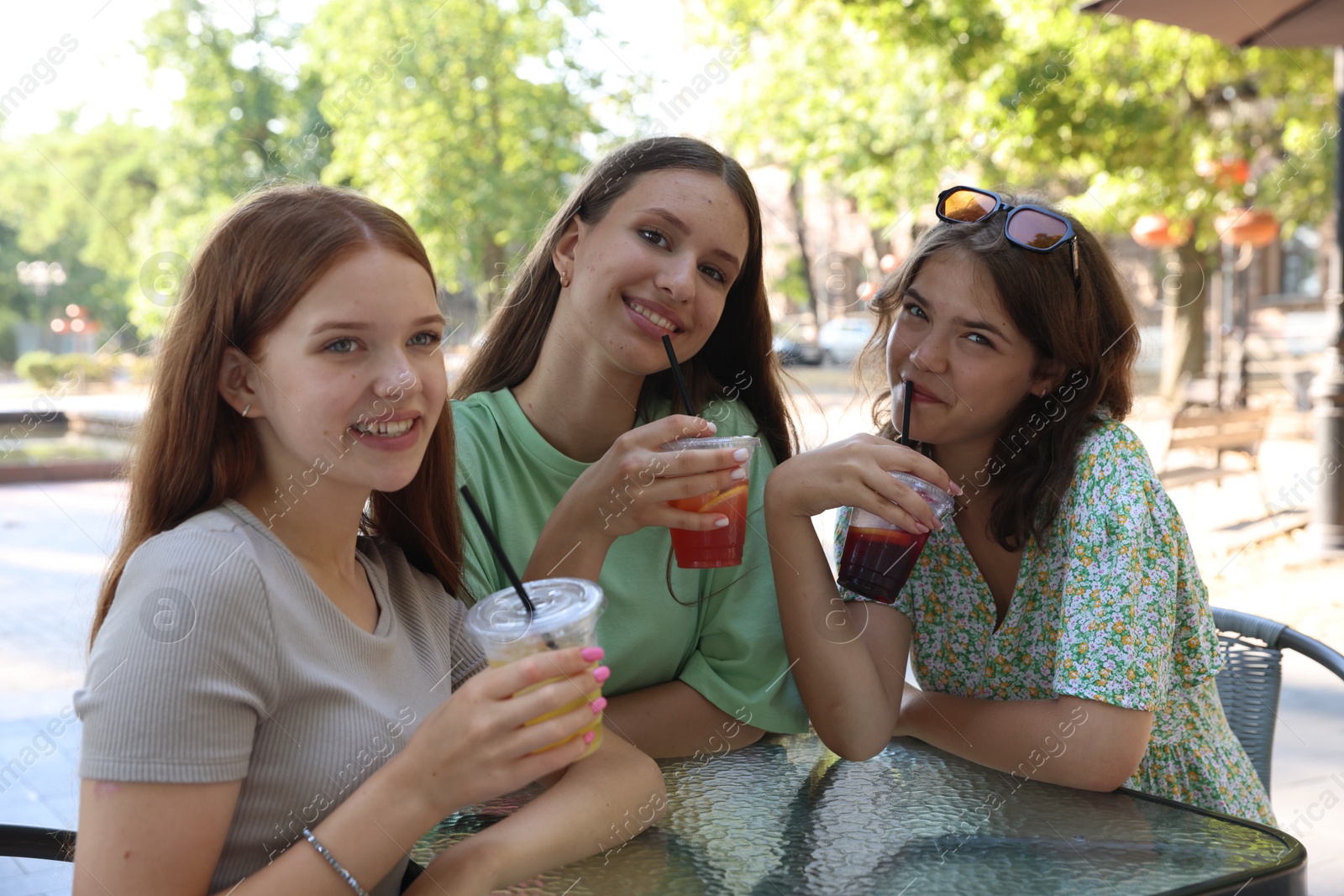 Friends enjoying refreshing drinks in outdoor cafe Photo of Friends enjoying refreshing drinks in outdoor cafe