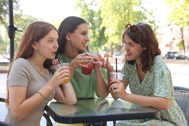 Photo of Friends enjoying refreshing drinks in outdoor cafe