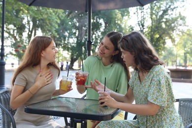 Photo of Friends enjoying refreshing drinks in outdoor cafe