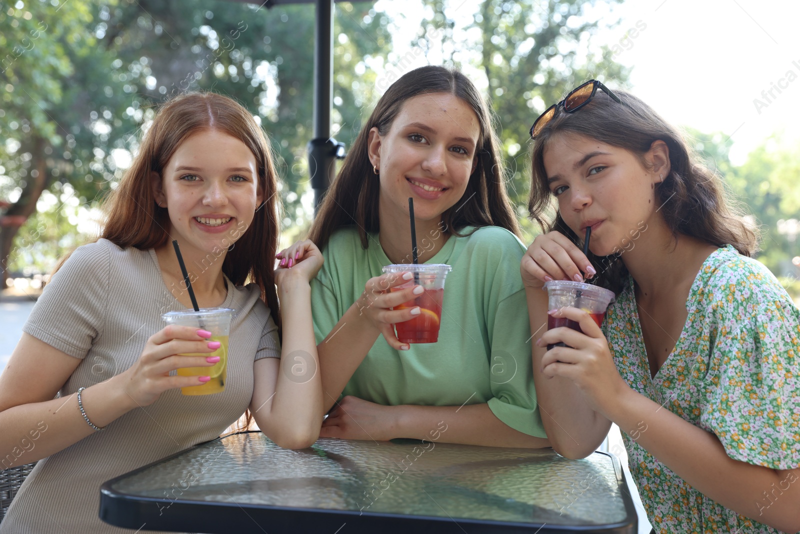 Friends enjoying refreshing drinks in outdoor cafe Photo of Friends enjoying refreshing drinks in outdoor cafe