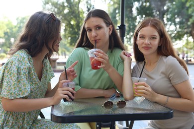 Photo of Friends enjoying refreshing drinks in outdoor cafe