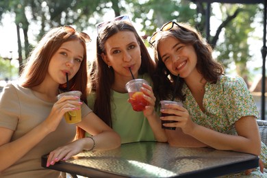 Photo of Friends enjoying refreshing drinks in outdoor cafe