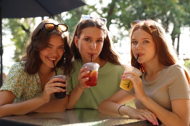 Photo of Friends enjoying refreshing drinks in outdoor cafe