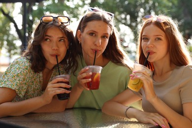 Photo of Friends enjoying refreshing drinks in outdoor cafe