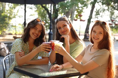 Photo of Friends enjoying refreshing drinks in outdoor cafe