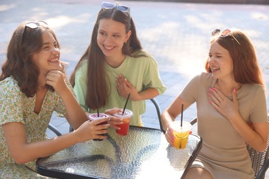Photo of Friends enjoying refreshing drinks in outdoor cafe