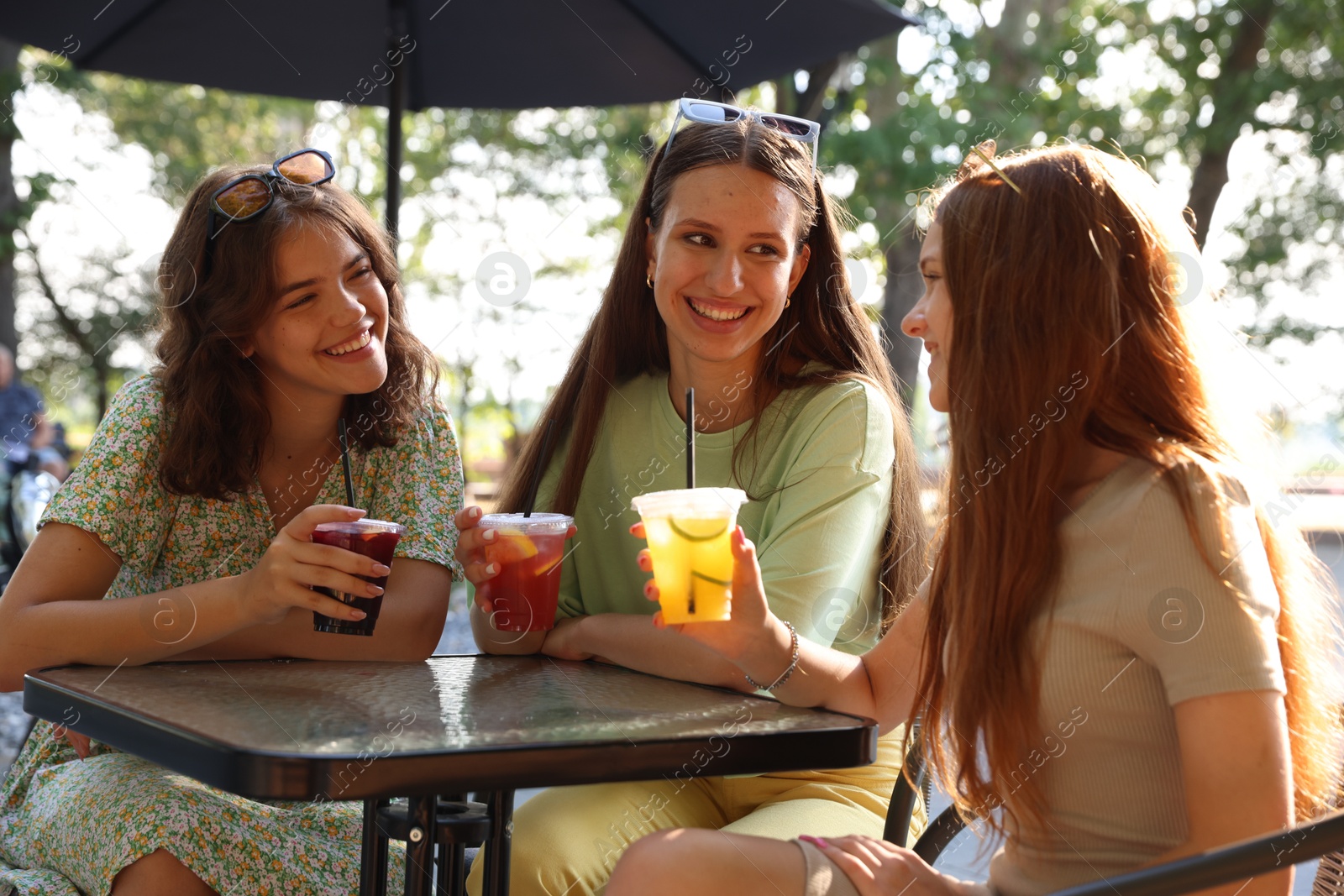 Photo of Friends enjoying refreshing drinks in outdoor cafe