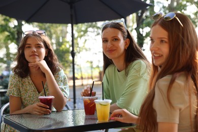 Photo of Friends enjoying refreshing drinks in outdoor cafe