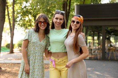 Photo of Portrait of happy friends with sunglasses outdoors