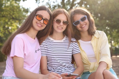 Photo of Portrait of happy friends in sunglasses outdoors