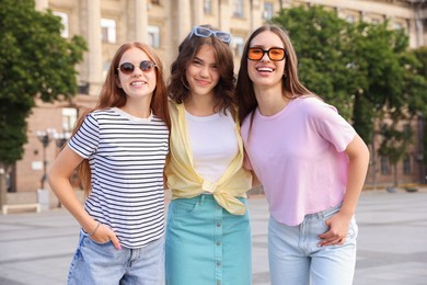 Photo of Happy friends walking together on city street