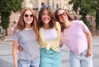 Photo of Happy friends walking together on city street