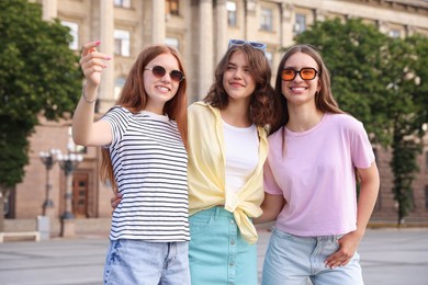 Photo of Happy friends walking together on city street