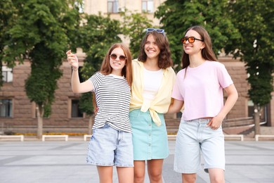 Photo of Happy friends walking together on city street