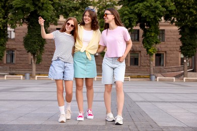 Photo of Happy friends walking together on city street