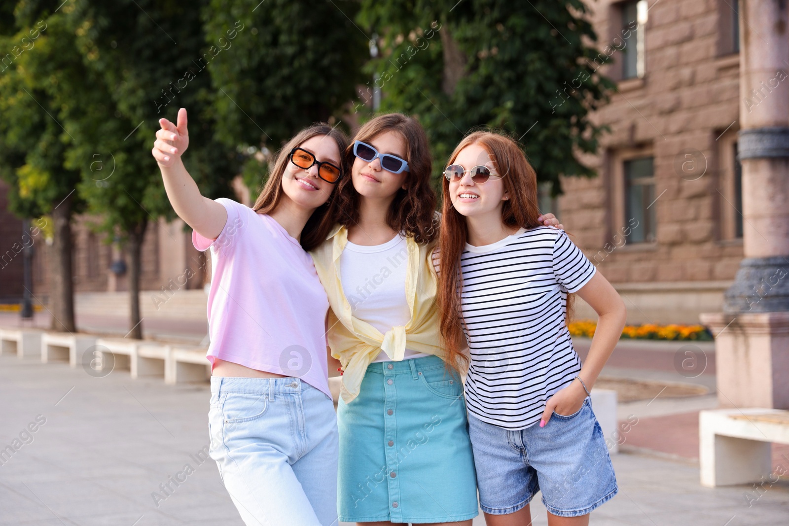 Photo of Happy friends walking together on city street