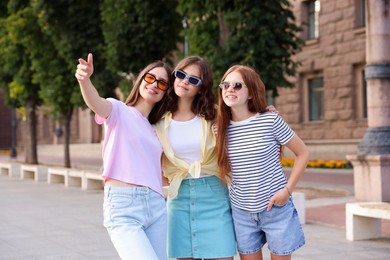 Photo of Happy friends walking together on city street