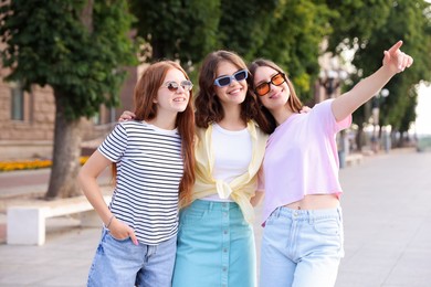 Photo of Happy friends walking together on city street