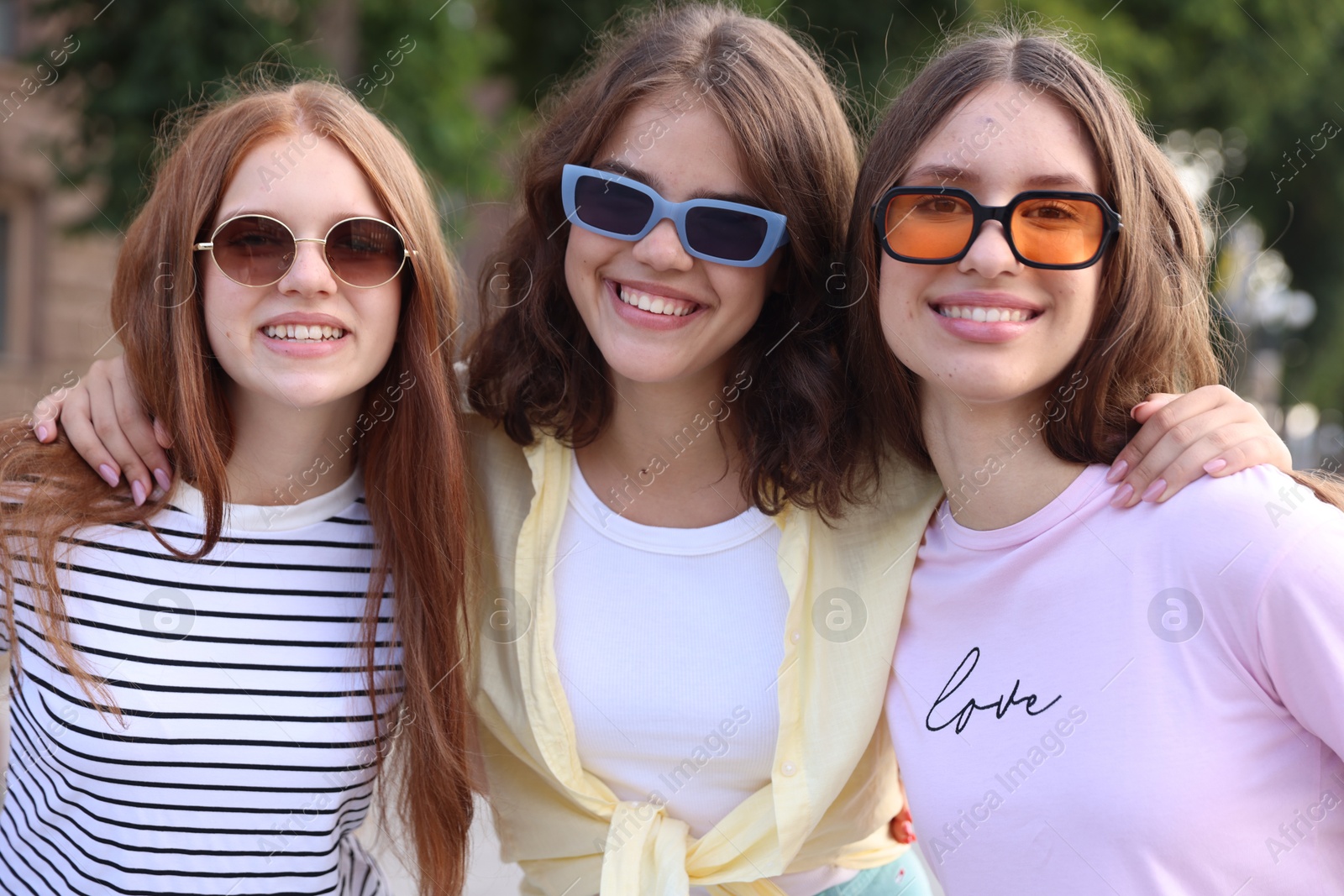 Photo of Portrait of happy friends in sunglasses outdoors