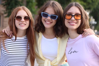 Photo of Portrait of happy friends in sunglasses outdoors