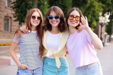 Photo of Portrait of happy friends in sunglasses outdoors