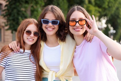 Photo of Portrait of happy friends in sunglasses outdoors